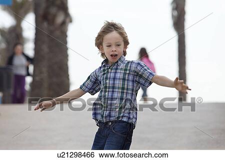 Stock Photograph - Boy riding skateboard outdoors. Fotosearch