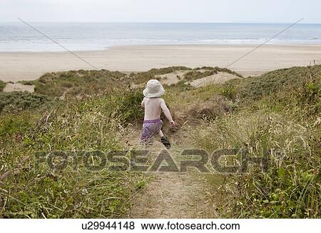 Stock Photo - Boy running on sand path in grass. Fotosearch