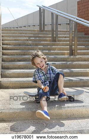 Boy sitting on skateboard on steps View Large Photo Image Stock Image - Boy sitting on skateboard on steps. Fotosearch
