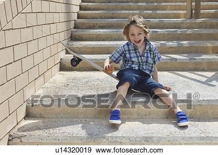 Boy sitting on skateboard on steps View Large Photo Image Stock Photo - Boy sitting on skateboard on steps. Fotosearch