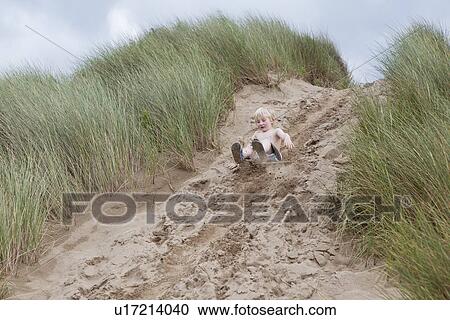Boy sliding down sand dune View Large Photo Image Stock Image - Boy sliding down sand dune. Fotosearch