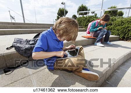 Boy using tablet computer outdoors View Large Photo Image Stock Image - Boy using tablet computer outdoors. Fotosearch