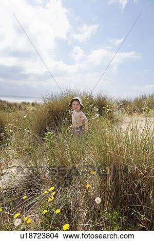 Picture - Boy walking in grassy sand. Fotosearch