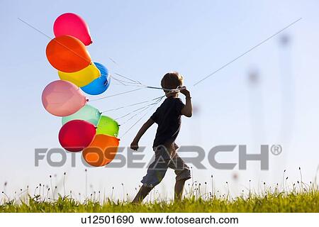 Boy with colorful balloons in grass View Large Photo Image Stock Image - Boy with colorful balloons in grass. Fotosearch