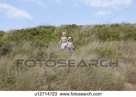 Boys playing on grassy hillside View Large Photo Image Stock Image - Boys playing on grassy hillside. Fotosearch