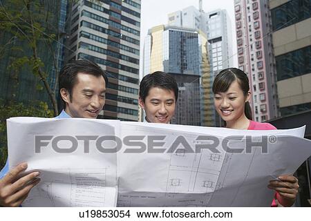 Picture - Business people reading blueprints. Fotosearch