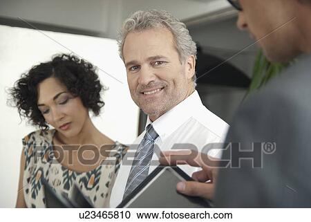 Stock Image - Business people talking in office. Fotosearch