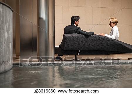 Business people talking on sofa in lobby View Large Photo Image Stock Image - Business people talking on sofa in lobby. Fotosearch