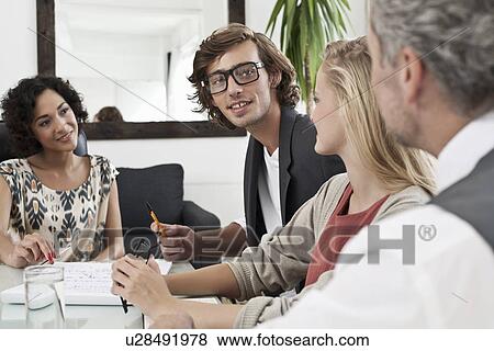 Business people working together at desk View Large Photo Image Stock Photo - Business people working together at desk. Fotosearch