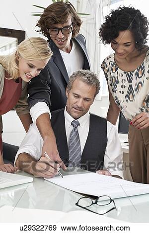 Business people working together at desk View Large Photo Image Stock Photo - Business people working together at desk. Fotosearch