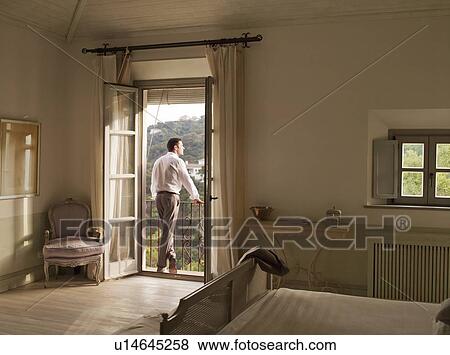 Businessman admiring view from balcony View Large Photo Image Stock Photo - Businessman admiring view from balcony. Fotosearch