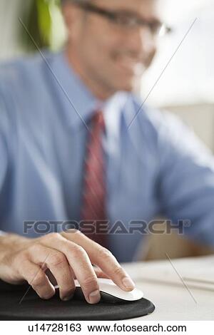 Businessman clicking mouse at desk View Large Photo Image Stock Image - Businessman clicking mouse at desk. Fotosearch