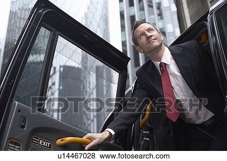 Businessman climbing out of taxi cab View Large Photo Image Stock Photo - Businessman climbing out of taxi cab. Fotosearch