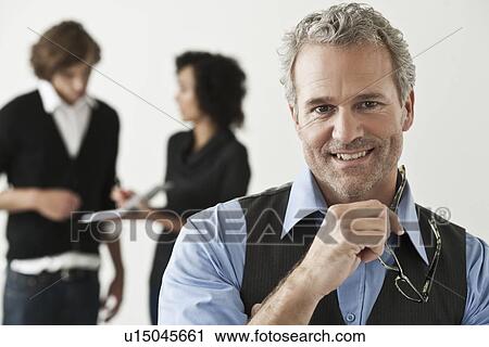 Businessman holding glasses in office View Large Photo Image Stock Image - Businessman holding glasses in office. Fotosearch