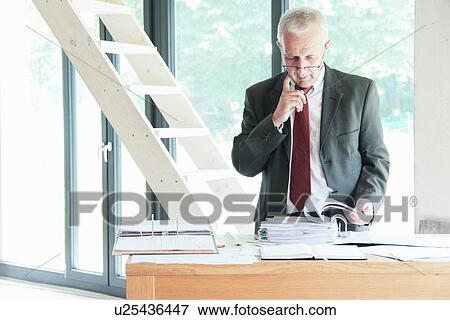 Stock Photo - Businessman leafing through binder. Fotosearch