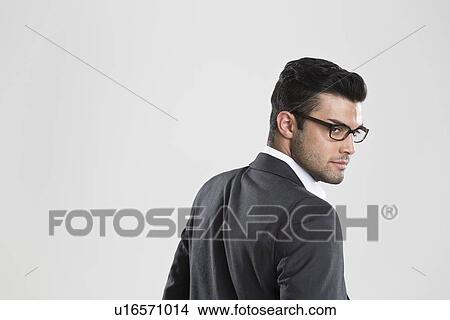 Businessman looking over his shoulder View Large Photo Image Picture - Businessman looking over his shoulder. Fotosearch