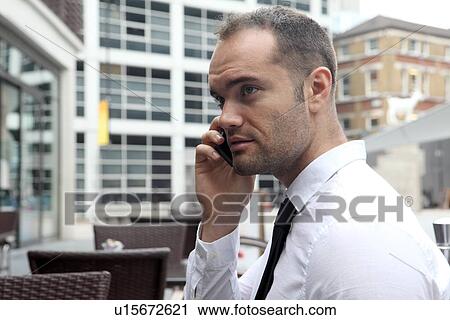 Businessman on cell phone at cafe View Large Photo Image Stock Image - Businessman on cell phone at cafe. Fotosearch