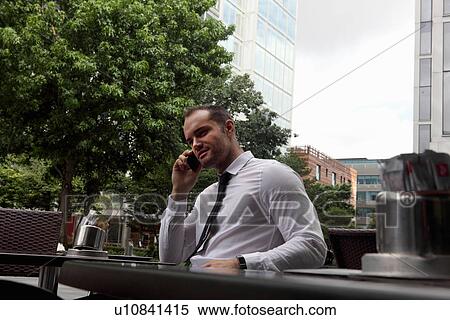Businessman on cell phone at cafe View Large Photo Image Stock Photography - Businessman on cell phone at cafe. Fotosearch