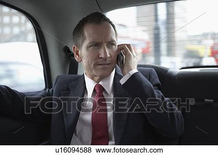 Businessman on cell phone in backseat View Large Photo Image Stock Photo - Businessman on cell phone in backseat. Fotosearch