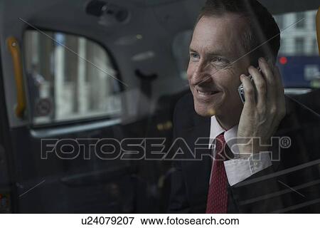 Businessman on cell phone in backseat View Large Photo Image Stock Photo - Businessman on cell phone in backseat. Fotosearch