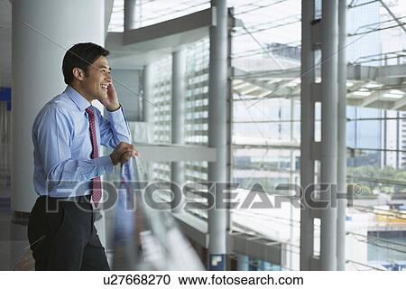 Businessman on cell phone in office View Large Photo Image Stock Image - Businessman on cell phone in office. Fotosearch