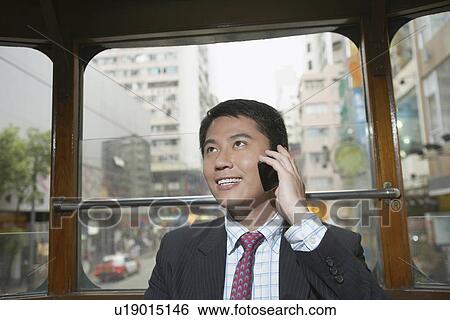 Businessman on cell phone on bus View Large Photo Image Stock Photograph - Businessman on cell phone on bus. Fotosearch