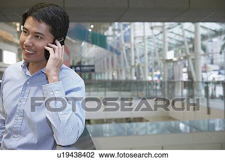 Businessman on cell phone on city street View Large Photo Image Stock Image - Businessman on cell phone on city street. Fotosearch