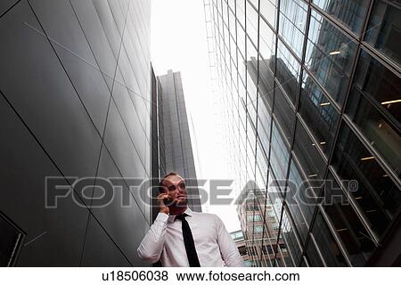 Businessman on cell phone on city street View Large Photo Image Stock Photo - Businessman on cell phone on city street. Fotosearch
