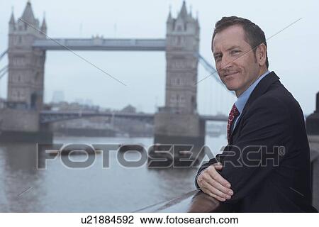 Businessman overlooking urban river View Large Photo Image Stock Image - Businessman overlooking urban river. Fotosearch