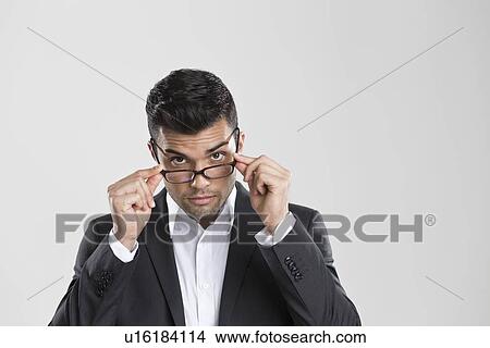 Businessman peering over glasses View Large Photo Image Picture - Businessman peering over glasses. Fotosearch