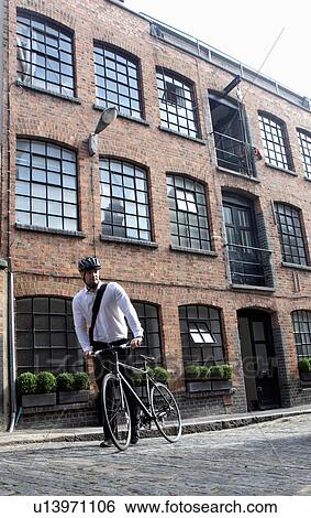 Businessman pushing bicycle outdoors View Large Photo Image Stock Photograph - Businessman pushing bicycle outdoors. Fotosearch