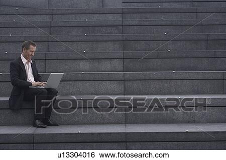 Businessman reading newspaper on steps View Large Photo Image Stock Photograph - Businessman reading newspaper on steps. Fotosearch