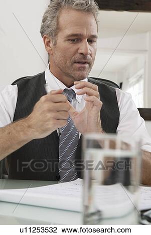 Businessman reading papers at desk View Large Photo Image Stock Image - Businessman reading papers at desk. Fotosearch