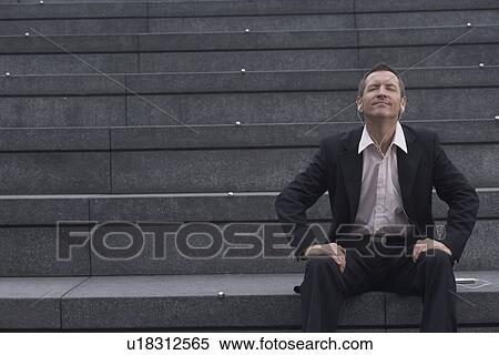 Stock Photography - Businessman sitting on city steps. Fotosearch