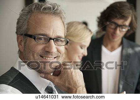 Businessman smiling in office View Large Photo Image Stock Image - Businessman smiling in office. Fotosearch