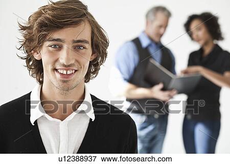 Businessman smiling in office View Large Photo Image Stock Photo - Businessman smiling in office. Fotosearch