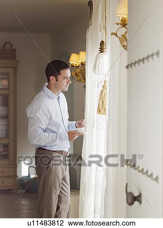 Businessman standing at window View Large Photo Image Stock Image - Businessman standing at window. Fotosearch