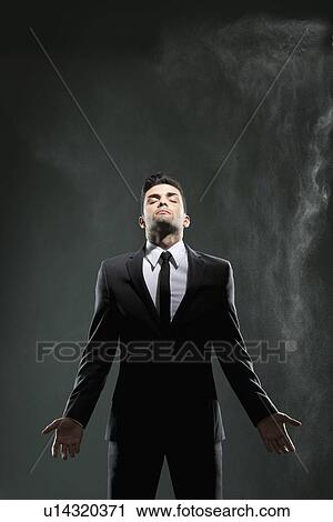 Stock Image - Businessman standing in smoky room. Fotosearch