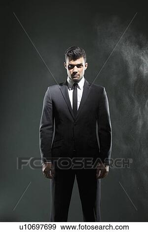 Businessman standing in smoky room View Large Photo Image Stock Photo - Businessman standing in smoky room. Fotosearch