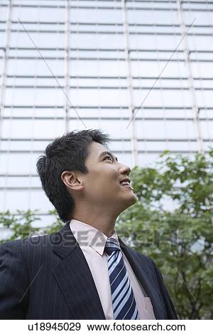 Stock Photo - Businessman standing on city street. Fotosearch