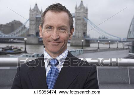 Picture - Businessman standing on urban rooftop. Fotosearch