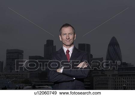 Businessman standing on urban rooftop View Large Photo Image Stock Photo - Businessman standing on urban rooftop. Fotosearch