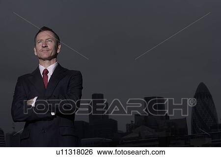 Businessman standing on urban rooftop View Large Photo Image Stock Photograph - Businessman standing on urban rooftop. Fotosearch