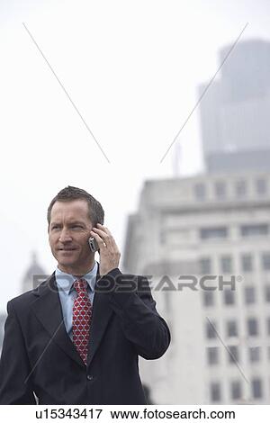 Stock Photo - Businessman talking on cell phone. Fotosearch