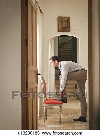 Businessman tying his shoe in home View Large Photo Image Stock Image - Businessman tying his shoe in home. Fotosearch