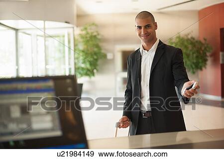 Businessman using cell phone in lobby View Large Photo Image Stock Photo - Businessman using cell phone in lobby. Fotosearch