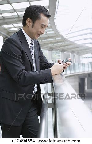 Businessman using cell phone View Large Photo Image Picture - Businessman using cell phone. Fotosearch