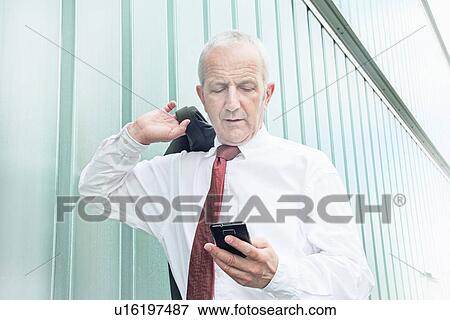Stock Photo - Businessman using cell phone. Fotosearch
