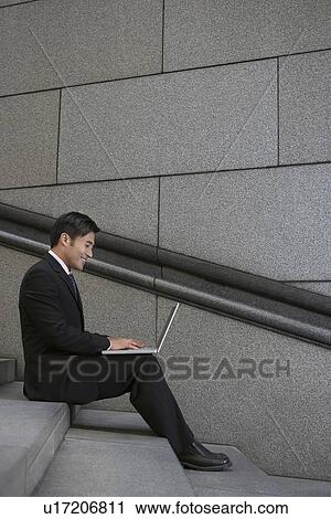 Businessman using laptop on city steps View Large Photo Image Stock Image - Businessman using laptop on city steps. Fotosearch
