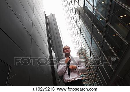 Stock Image - Businessman walking on city street. Fotosearch